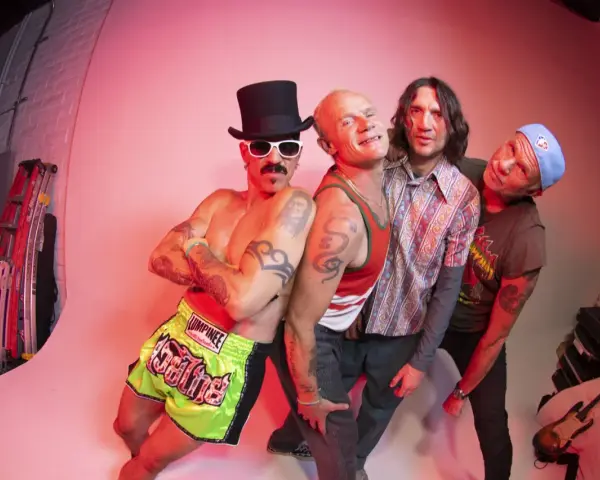 Les membres de Red Hot Chili Peppers posent ensemble, un groupe de rock iconique.