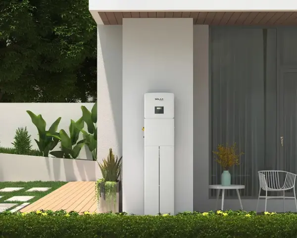 Biały magazyn energii 5 kW, stojący przy nowoczesnym domu, z zielenią i tarasem. Zastanawiasz się, na ile wystarczy taki magazyn energii?