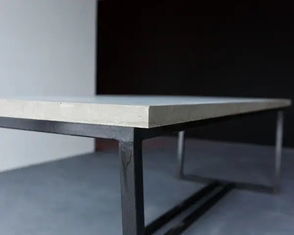 En stilren betongskiva på ett svart metallunderrede. Ytan är behandlad för att impregnera betongskivan och skydda den.
