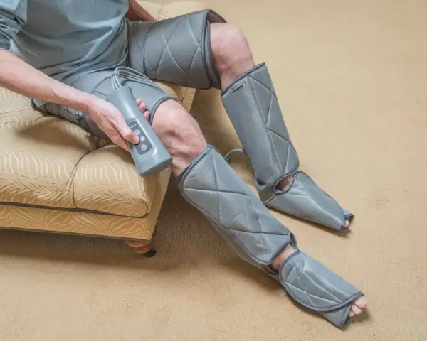 Man using a leg compression machine, enjoying the benefits of improved circulation and muscle recovery.