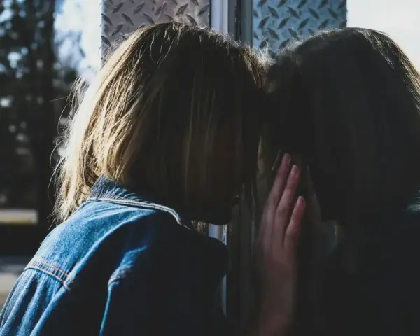 Dziewczyna w dżinsowej kurtce opiera czoło o szybę, jej odbicie jest niemal niewidoczne. Czasem czujemy się tak neurotyczni, że jedynym towarzyszem jest własne odbicie.