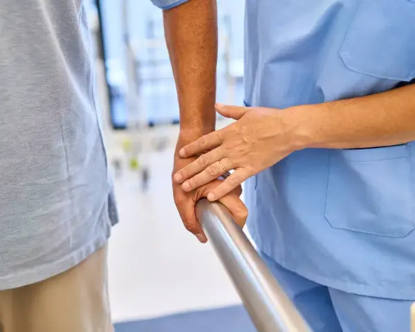 Fizjoterapeuta pomaga pacjentowi w rehabilitacji. Dowiedz się, ile wynosi zasiłek rehabilitacyjny.