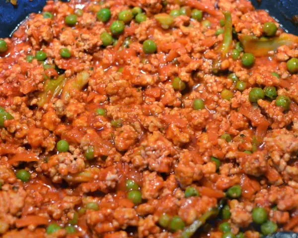 Pyszne spaghetti con piselli z mielonym mięsem i groszkiem w sosie pomidorowym.