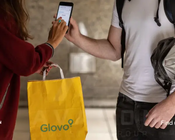 Kobieta płaci za dostawę Glovo telefonem. Różne glovo metody płatności są dostępne.