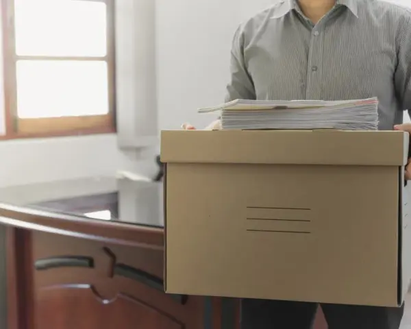Hombre con caja de cartón y papeles, listo para irse. ¿Los 15 días de preaviso son naturales o laborales?