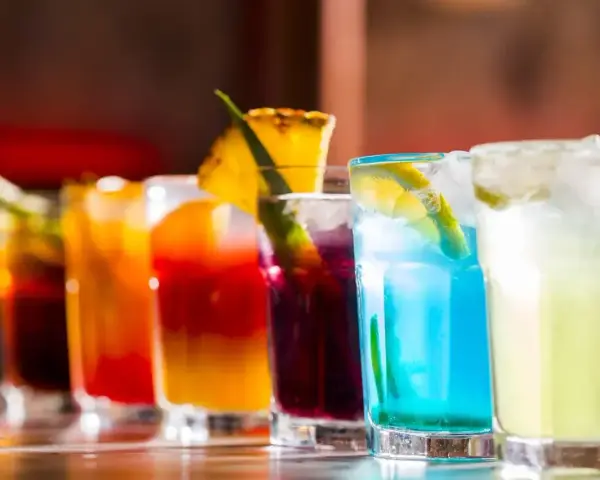 Kolorowe drinki na barze, idealne inspiracje, jak zrobić drinka. Od czerwonego, przez niebieski, po zielony.