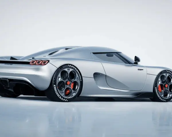 Srebrny Koenigsegg CC850 z czerwonymi zaciskami hamulcowymi i charakterystycznymi felgami.