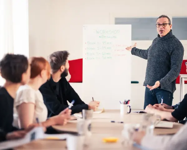 Man leder en workshop om möteskultur, där deltagarna fokuserar på kompetens utveckling.