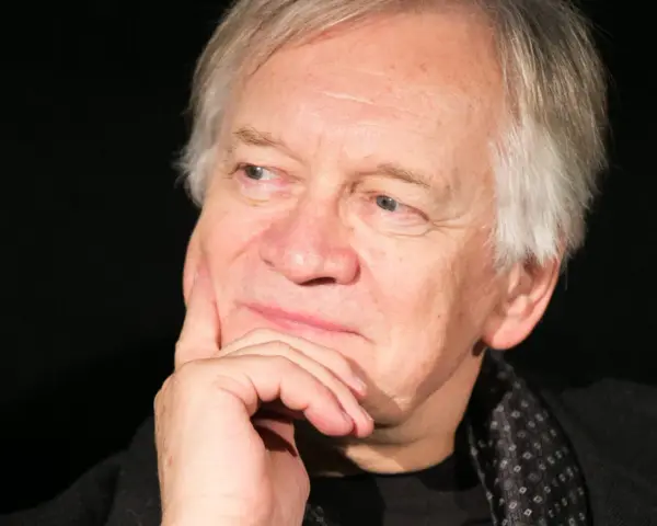 Portret Andrzeja Seweryna z dłonią podpartą na policzku. Zastanawia się, ile lat ma Andrzej Seweryn.