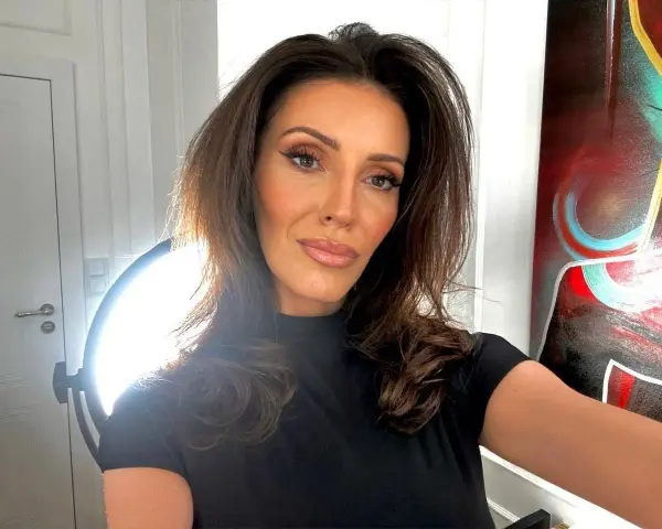 Dominika Serowska, wiek nieznany, pozuje do selfie w czarnej bluzce. W tle widać drzwi, lampę i abstrakcyjny obraz.