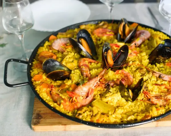Pyszna paella z owocami morza, idealne hiszpania jedzenie. Krewetki i małże na żółtym ryżu.