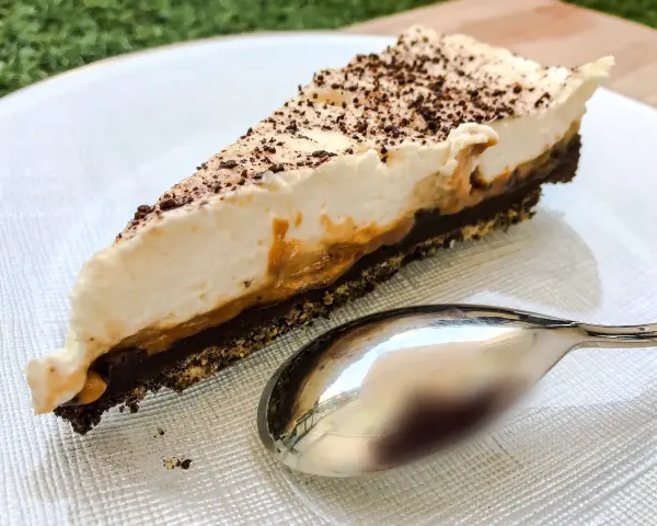 Pyszny kawałek banoffee pie z karmelem i bitą śmietaną, posypany czekoladą. Czy to lepszy wybór niż tarta cytrynowa?