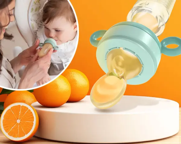 Mama karmi dziecko smoczkiem do owoców, który wygląda jak mały dzbanuszek z pomarańczowym płynem. Obok pomarańcze.