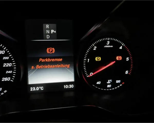 Mercedes-Armaturenbrett: gelbe Warnleuchte für die Feststellbremse leuchtet. Die Anzeige "Parkbremse" und "s. Betriebsanleitung" ist sichtbar.
