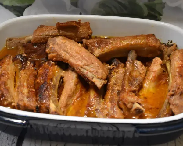 Pieczone żeberka w sosie w naczyniu żaroodpornym.
