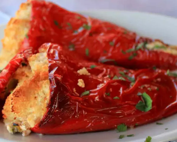Peperoni ripieni in padella, dorati e profumati, con un ripieno invitante e una spolverata di prezzemolo fresco.