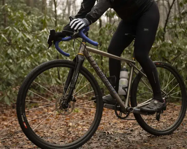 Cyclist adjusting saddle height to prevent calf pain.