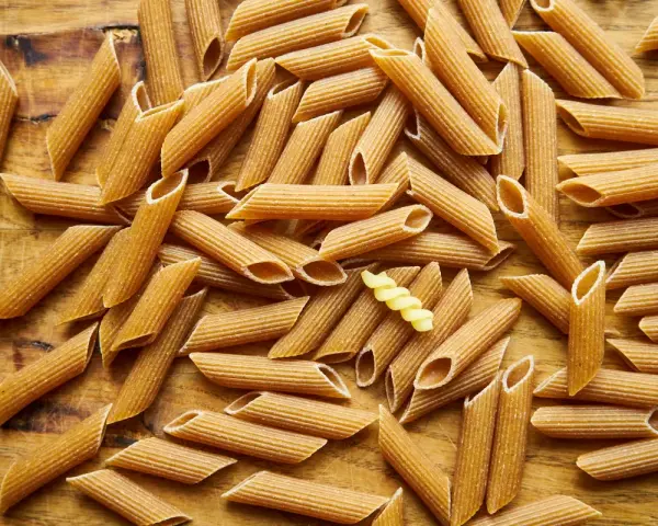 Makaron pełnoziarnisty (ciemny) vs jasny - porównanie kcal. Na zdjęciu penne i jeden fusilli.