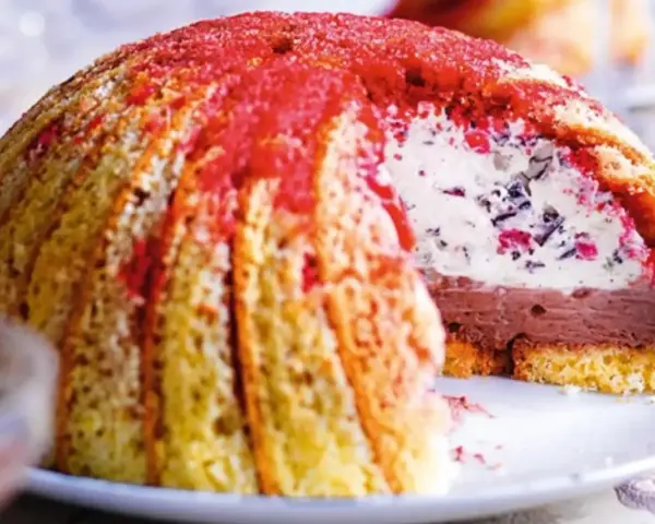 Un delizioso dolce, simile ai dolci tipici toscani, con strati di gelato al cioccolato e crema, ricoperto da savoiardi e spolverato di rosso.