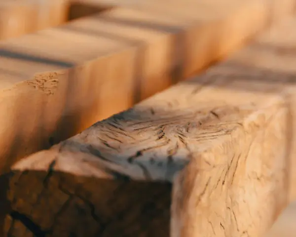 Close-up of rough-hewn wooden beams, evoking the question: was Jesus a carpenter?