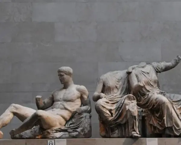 Statues grecques antiques, dont un homme musclé assis et des figures féminines drapées, témoignant de l'art hellénistique.