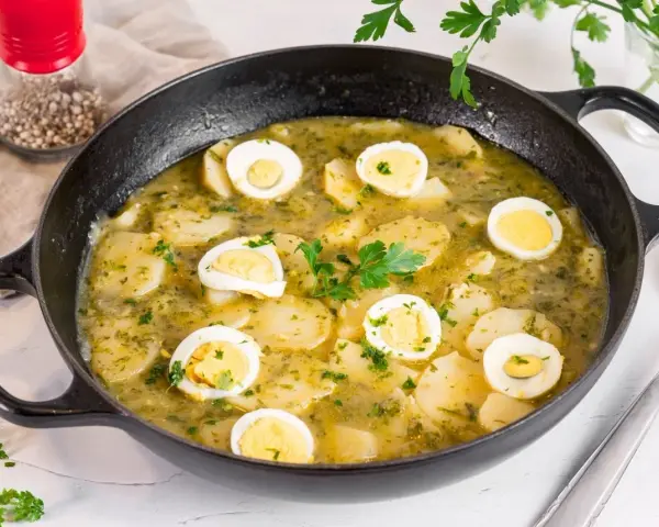 Patatas en salsa verde con huevos duros, un plato reconfortante y lleno de sabor, listo para disfrutar.