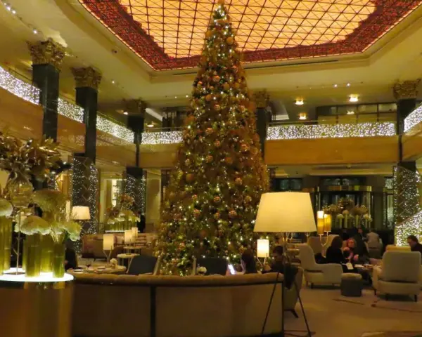 Elegancka wigilia w hotelu. Ogromna choinka i złote dekoracje tworzą świąteczną atmosferę.