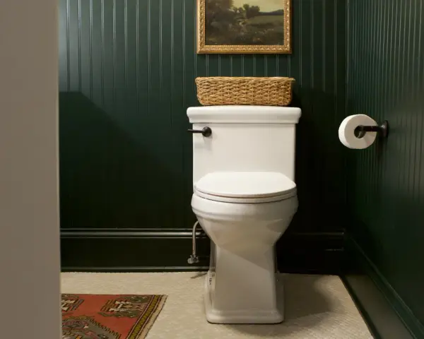A white toilet with a basket on top, ready for a tutorial on how to replace toilet seat.