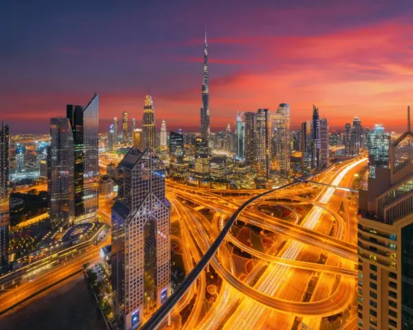 Wieczorny widok na Dubaj z drapaczami chmur i autostradą. W tle widać Burdż Chalifa. To miasto, gdzie kwitnie handel i **waluta Dubaju** jest symbolem rozwoju.