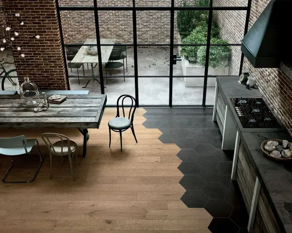 Un moderno spazio industriale dove accostare parquet e piastrelle esagonali crea un design unico.