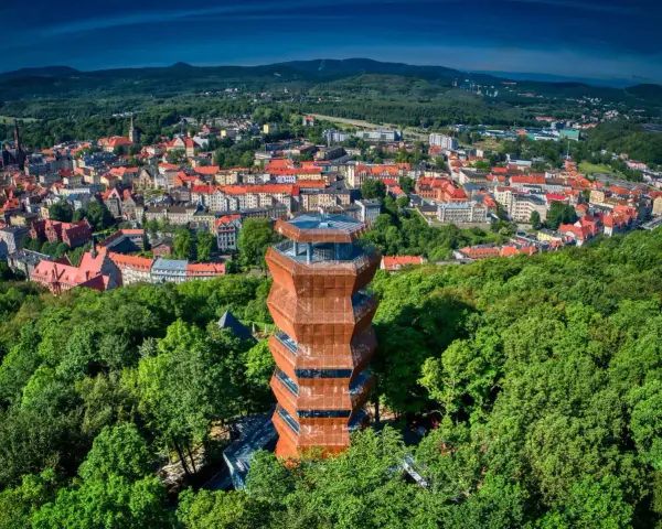Nowoczesna wieża widokowa w otoczeniu zieleni, z której rozpościera się panorama miasta. To idealny punkt widokowy Wałbrzych.