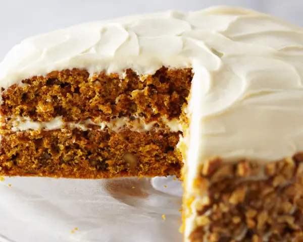 Tarta de zanahoria y queso con glaseado cremoso y nueces picadas en los bordes. ¡Un postre irresistible!