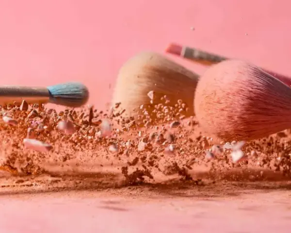 Pudry do makijażu w chmurze pyłu, pędzle do aplikacji pudru setting.