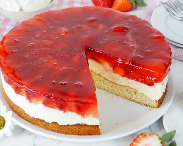 Ein saftiger Erdbeerkuchen mit Sahne und rotem Tortenguss, perfekt für jedes Erdbeerkuchen Rezept.
