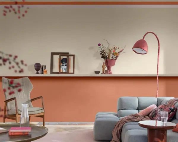 Soggiorno con pareti bicolore: la parte inferiore è color terracotta, quella superiore color crema. Arredamento moderno con divano grigio e poltrona.