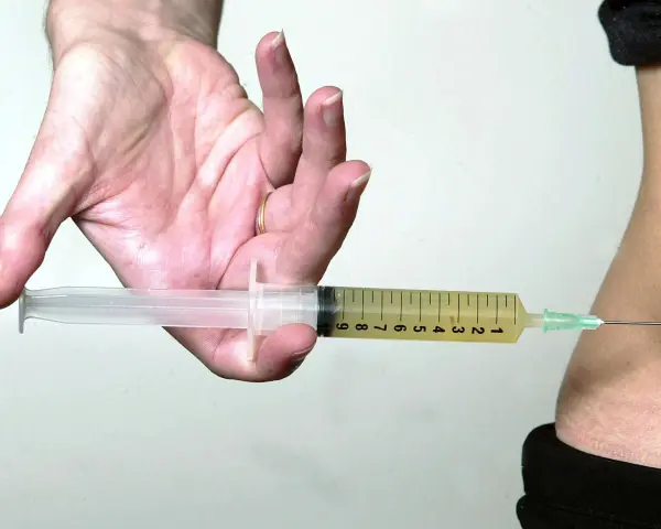 Spritze statt thrombose tabletten: Eine Spritze wird in den Bauch eingeführt, um eine Thrombose zu behandeln, besonders wichtig auf einem langen Flug.