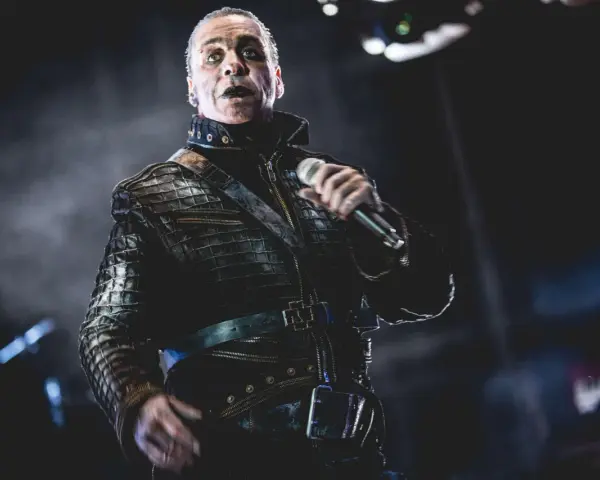 Till Lindemann w skórzanej kurtce, z mikrofonem w dłoni, jakby opowiadał historię swojej żonie.