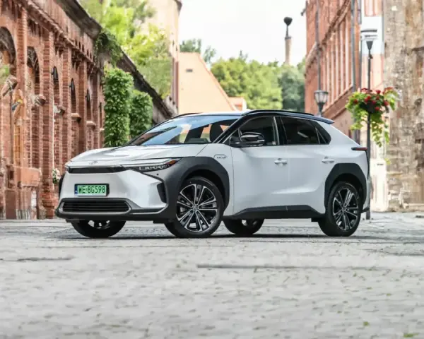 Biała Toyota bZ4X na brukowanej uliczce, gotowa na długie podróże. Sprawdź jej imponujący zasięg!