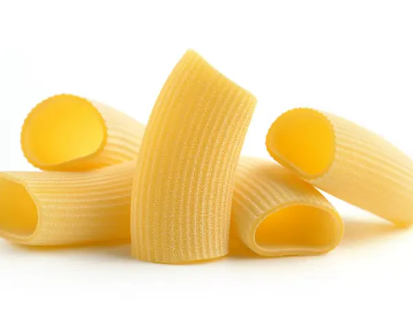 Kilka kawałków makaronu rigatoni, z charakterystycznymi rowkami, gotowych do sosu.