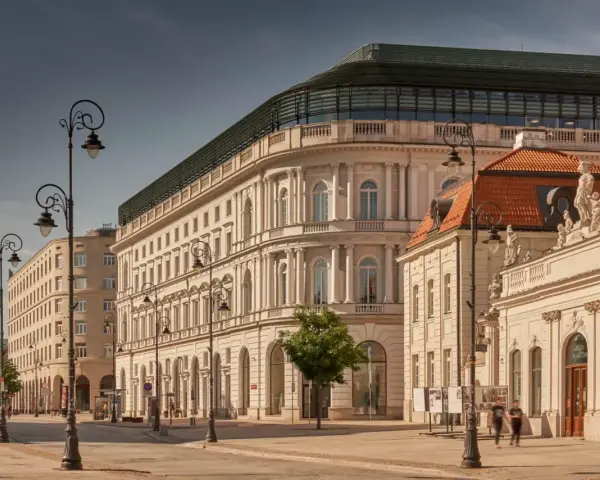 Elegancka kamienica z nowoczesnym dachem, być może najdroższy hotel w Polsce, przy słonecznej ulicy z zabytkowymi latarniami.