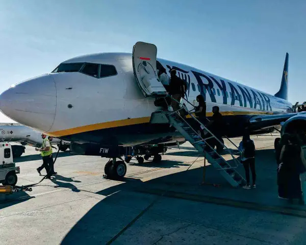 Ryanair samolot, pasażerowie wsiadają. Pamiętaj o zasadach, jak przewozić leki w samolocie Ryanair, by podróż przebiegła sprawnie.