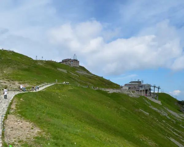 Kamienista ścieżka prowadzi na szczyt Kasprowego Wierchu. Widać tam budynki i kolej linową. Wysokość robi wrażenie!