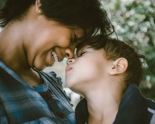 Ein inniges Lächeln verbindet Mutter und Kind. Ihre Nasen berühren sich, ein Moment purer, unendlich liebe zum Kind.