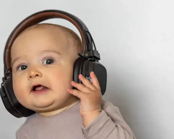 Un bébé curieux avec un casque anti-bruit. Quand utiliser un casque anti-bruit bébé à partir de quel âge ?
