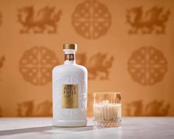 Elegancka butelka Aber Falls Cream Liqueur i szklanka z lodem, idealne na chwilę relaksu z tym wyśmienitym irish cream.