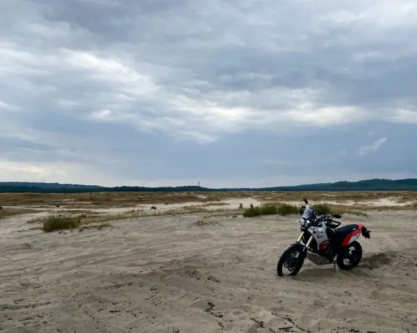 Motocykl na piaszczystym terenie, idealny na szlak Orlich Gniazd samochodem trasę.