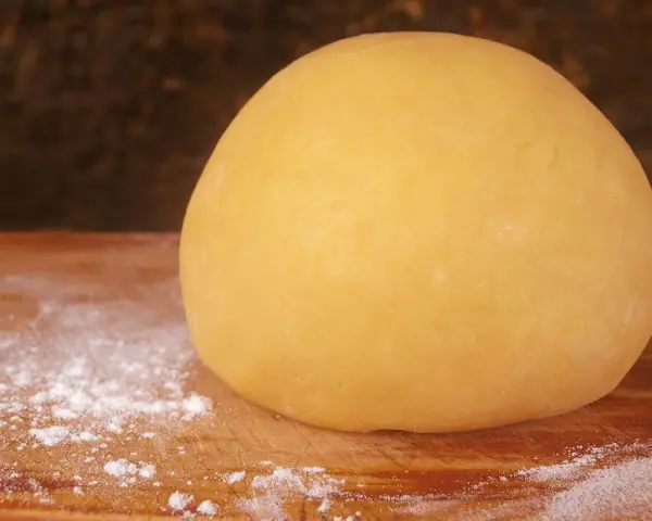 Impasto giallo dorato, pronto per diventare la base perfetta per una deliziosa pasta frolla per pastiera.