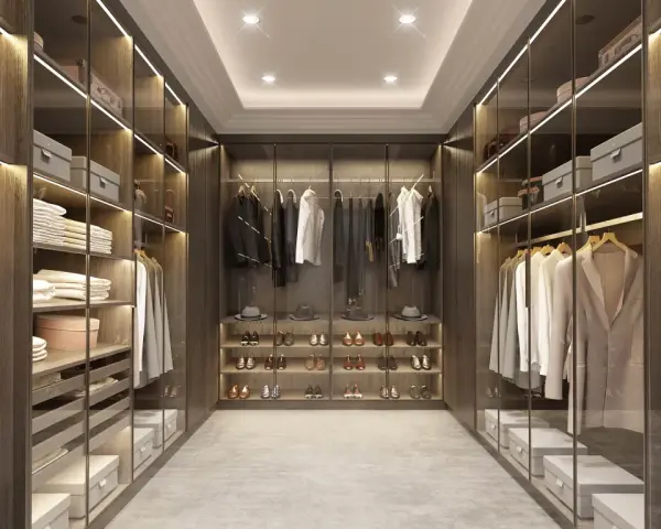 Cabina armadio aperta o chiusa, con abiti ordinati su mensole e grucce, scarpe esposte e scatole contenitive.