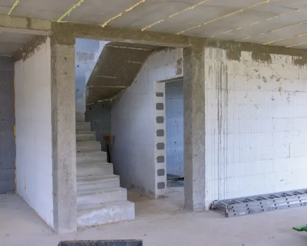 Wnętrze w budowie, betonowe schody, otwór pod drzwi 80, ściany z bloczków, drabina.