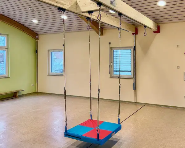 Therapieschaukel für Kinder im Test. Die Schaukel hängt von einer Deckenkonstruktion herab und ist bereit für den Einsatz.